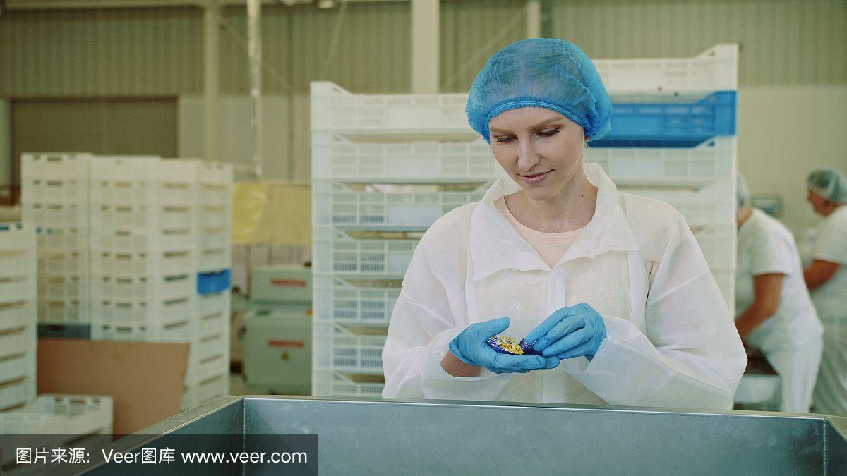 糖果工廠.工廠工人檢查包裝機(jī)器